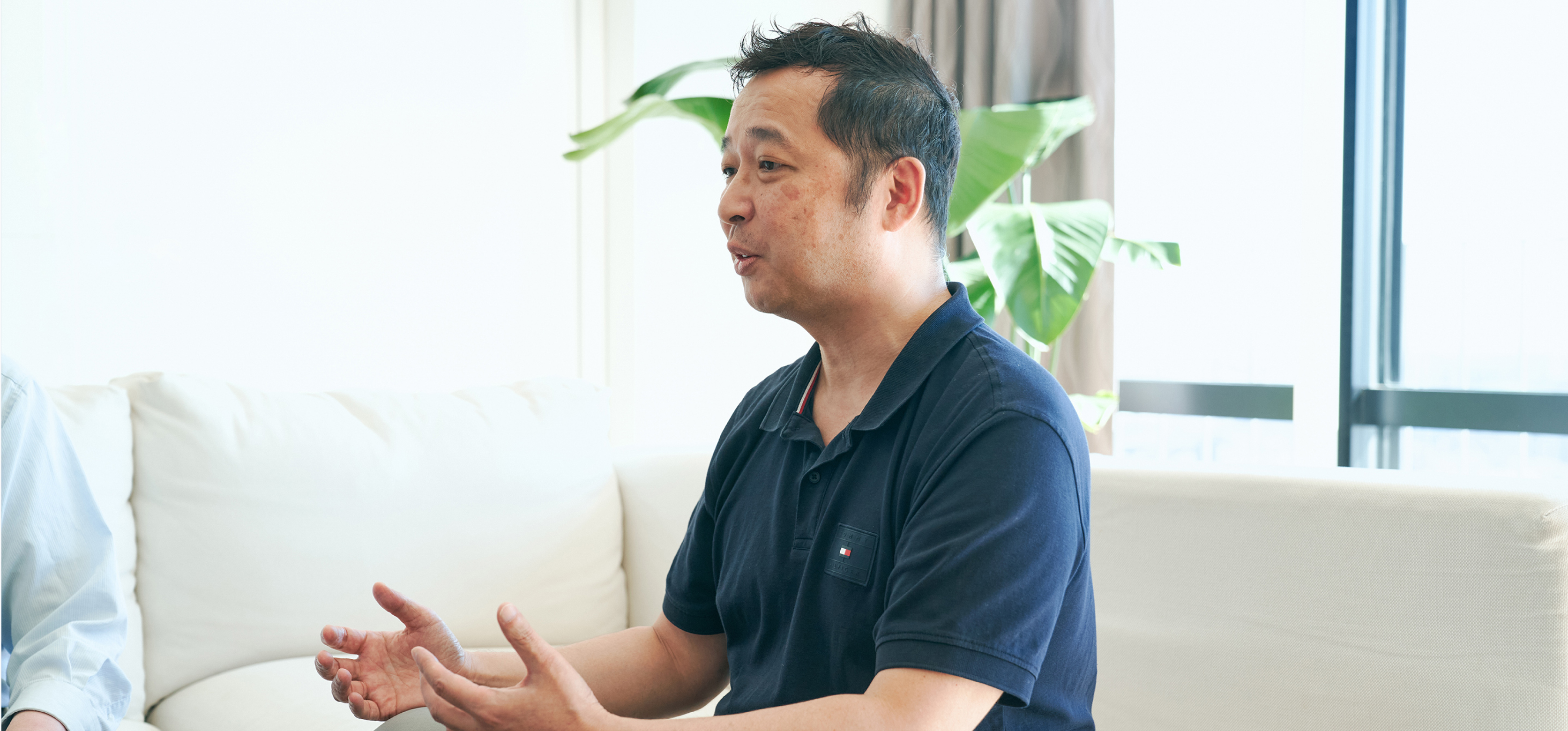 Mr. Hatanaka sitting on the sofa talking