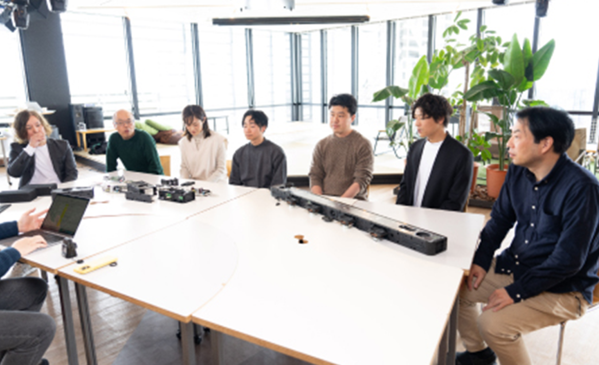 Image of the team sitting around a table.