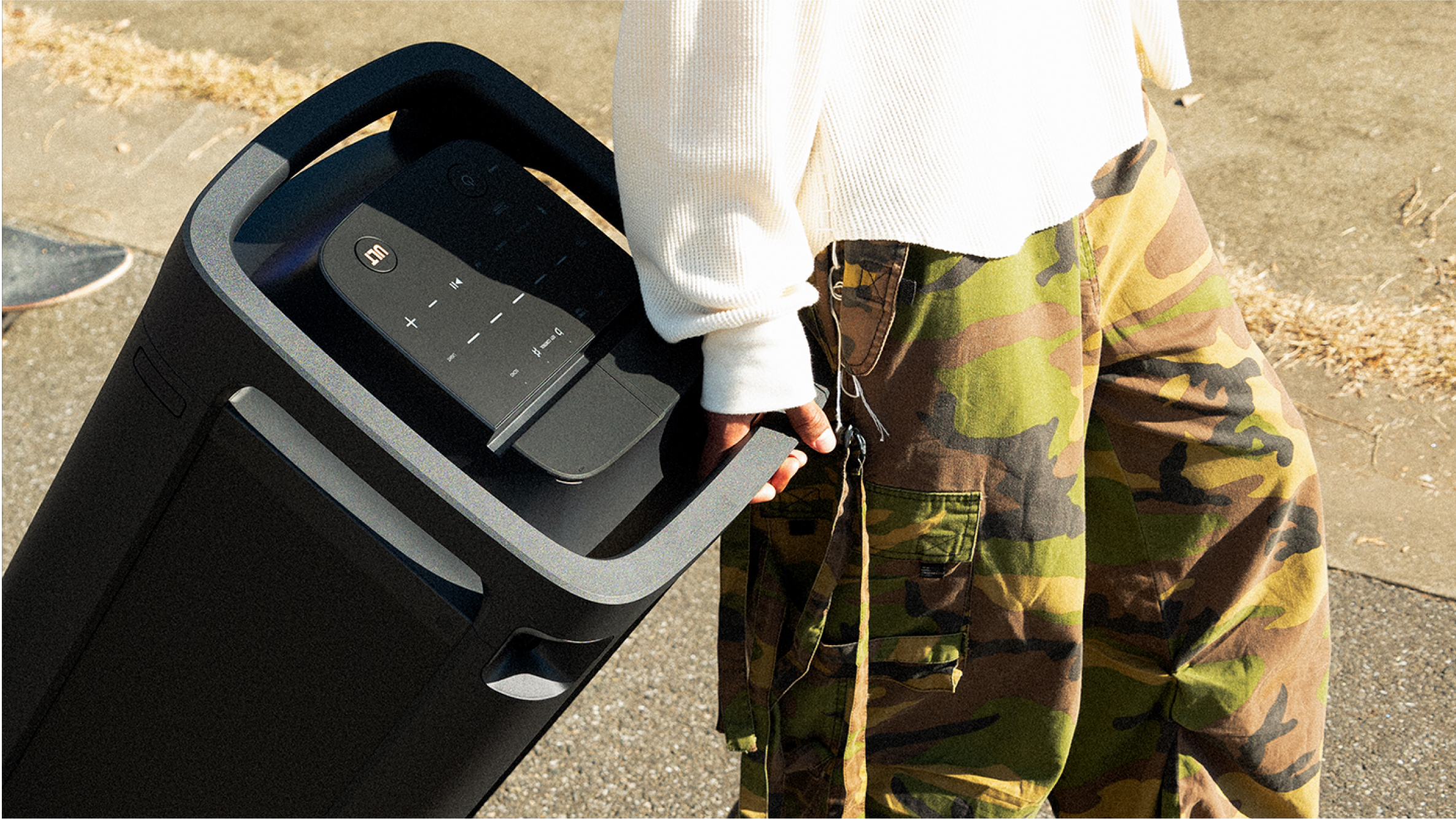 A person using the integrated top handle on the TOWER 9AC speaker to pull it behind them